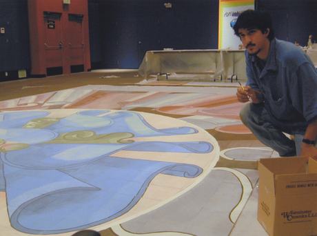 Dakota Warren painting a large floor mural